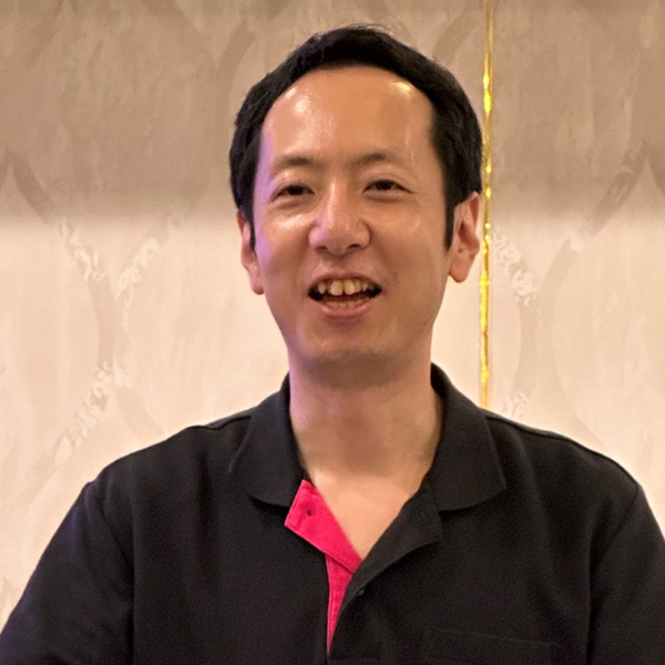 Profile pic of Masahito Zembutsu showing smiling dark-haired man wearing black and red shirt.